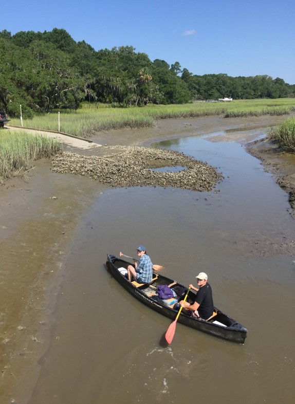 Two people in a canoe in a tidal creek